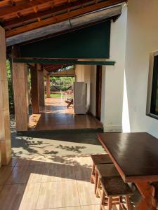a living room with a table and a refrigerator at Pousada Rancho Dona Lú Solo in Pereira Barreto +16 photos