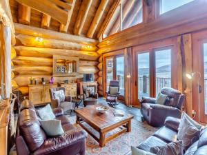 a living room with leather furniture in a log cabin at Molalatau Lodge in Lairg