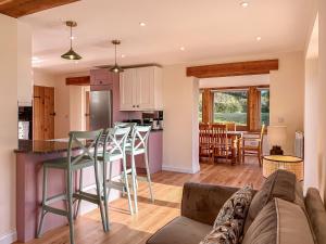 a kitchen and living room with a couch and a table at Quabbs Head Cottage in Mathon