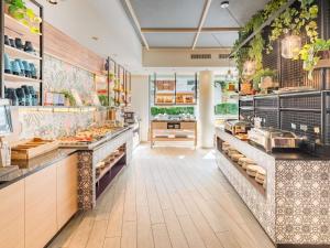 a large kitchen with a counter with food at Ibis Styles Wien City in Vienna