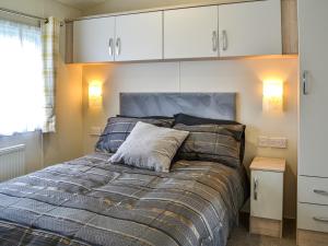 a bed in a bedroom with white cabinets at Lodge 43 Bridlington Holiday Park - Uk47517 in Carnaby +8 photos