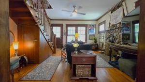 a living room with a staircase and a couch and a table at 1920s Phoenicia Bungalow with Vintage Furnishings, Sauna, Fireplace, & Fenced Backyard in Phoenicia