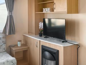 a tv sitting on a stand in a room at Sea Breeze in Heysham