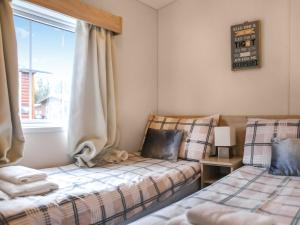 twee bedden in een kamer met een raam bij Craig Rossie Lodge in Auchterarder