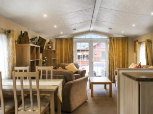 een woonkamer met een bank en een tafel bij Craig Rossie Lodge in Auchterarder