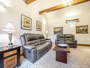 sala de estar con muebles de cuero y mesa en The Stables - Uk44515, en North Thoresby