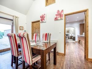 Un comedor con mesa y sillas de madera. en The Stables - Uk44515, en North Thoresby