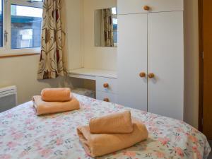 a bedroom with a bed with two towels on it at Pinewood in Brundall