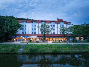 a large building with a river in front of it at Ibis Styles Regensburg in Regensburg