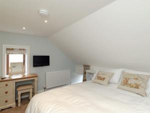 Un dormitorio con una cama blanca y un televisor. en The Forge, en Roxby 13 fotos más