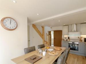 cocina y comedor con mesa y reloj en The Forge, en Roxby