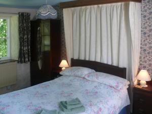 Un dormitorio con una cama con dos toallas encima. en Bridge Cottage, en Lockerbie
