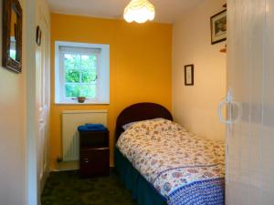 Un dormitorio pequeño con una cama y una ventana. en Bridge Cottage, en Lockerbie 2 fotos más