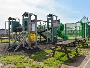 a playground with a slide and two benches at Marni's Seaview in Heysham