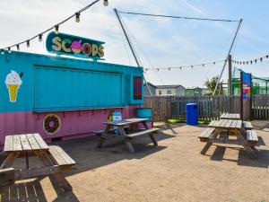 a playground with picnic tables and an ice cream shop at Marni's Seaview in Heysham