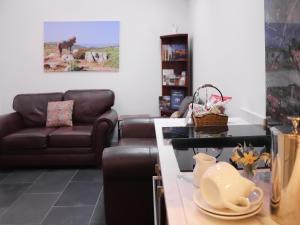 a living room with a couch and a table at Bwthyn Y Celyn in Conwy