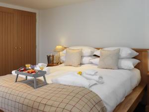a large white bed with a tray of food on it at Bwthyn Y Celyn in Conwy +11 photos