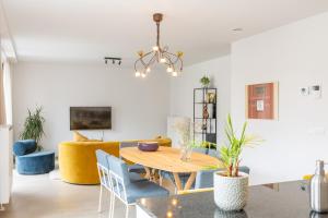 a living room with a wooden table and blue chairs at Conrad City Stay - 176 in Ostend