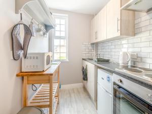 a kitchen with white cabinets and a counter top at Buttercup Apartment - Uk42382 in Bridlington