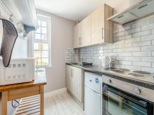 a kitchen with white appliances and a counter top at Buttercup Apartment - Uk42382 in Bridlington