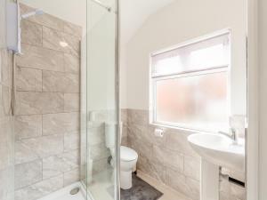 a bathroom with a toilet and a sink and a shower at Buttercup Apartment - Uk42382 in Bridlington
