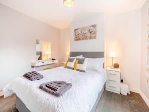 a bedroom with a white bed with two towels on it at Buttercup Apartment - Uk42382 in Bridlington