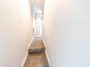 a hallway with a stairway leading up to a room at Buttercup Apartment - Uk42382 in Bridlington +6 photos