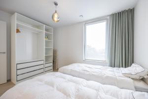 a bedroom with two beds and a window at Conrad City Stay - 176 in Ostend