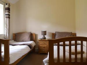 a bedroom with two beds and a lamp on a dresser at Durham Cottage-27765 in Wolsingham