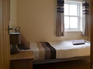 a bed in a bedroom with a window at Durham Cottage-27765 in Wolsingham +11 photos