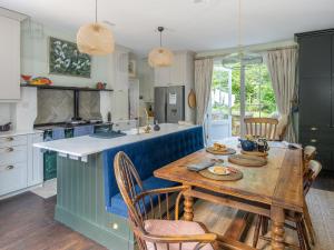 cocina con mesa de madera y cocina azul y blanco en Henge Estate, en Shrewton