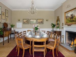 Un comedor con mesa y sillas y chimenea. en Henge Estate, en Shrewton