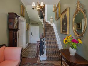 un pasillo con una escalera con espejo y flores en Henge Estate, en Shrewton 32 fotos más