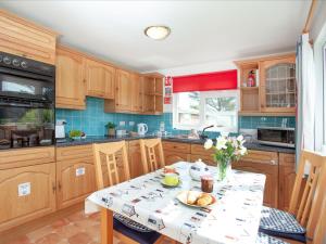 eine Küche mit einem Tisch, auf dem ein Teller mit Essen steht in der Unterkunft Lodge 73 - Uk43195 in Saint Merryn