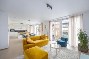 a living room with a yellow couch and a table at Conrad City Stay - 176 in Ostend