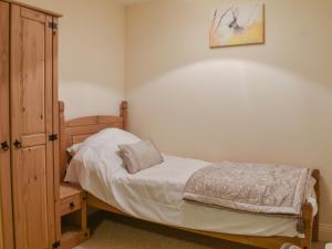 a small bedroom with a bed and a wooden cabinet at South Wing Coldharbour Park Farm in Rake +7 photos