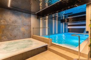 a large swimming pool with a hot tub in a room at Góralski Resort 2 z Basenem in Białka Tatrzańska