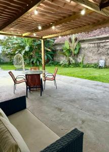 a patio with a table and chairs under a pergola at Mini Casa Privativa -Praia do Tombo in Guarujá