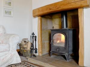 un soggiorno con divano e stufa a legna. di The Tottsie a Bassenthwaite