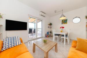 a living room with a couch and a table at Beach House Kocer in Pirovac