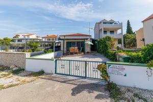 a house with a gate in front of a yard at Beach House Kocer in Pirovac