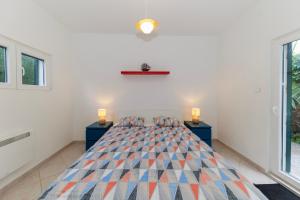 a bedroom with a large bed with two night stands at Beach House Kocer in Pirovac