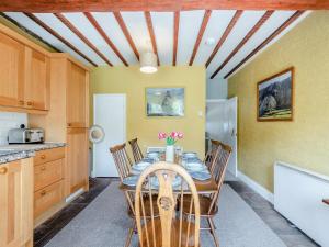 a kitchen and dining room with a table and chairs at Stybarrow View Cottage in Glenridding