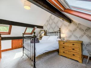 a bedroom with a bed and a wooden dresser at Stybarrow View Cottage in Glenridding