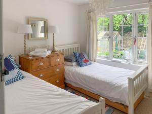 two twin beds in a room with a window at Castle Cottage in Ruan Lanihorne