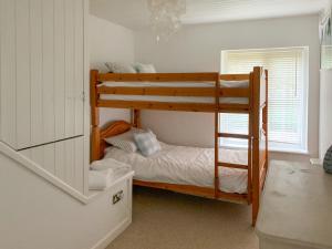 a bedroom with two bunk beds and a window at Castle Cottage in Ruan Lanihorne
