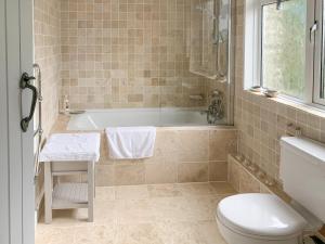 a bathroom with a tub and a toilet and a sink at Castle Cottage in Ruan Lanihorne +3 photos