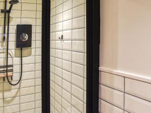 a shower in a bathroom with white tiles at White Mermaid - Uk42775 in Newborough