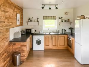 Una cocina con un frigorífico blanco y un lavavajillas. en Tay Lodge, en Aberfeldy