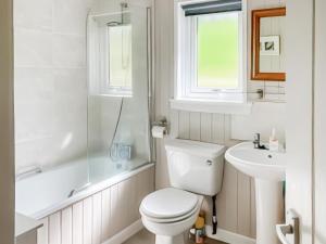 Un baño blanco con inodoro y lavabo. en Tay Lodge, en Aberfeldy